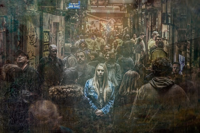 młoda kobieta w niebieskiej kurtce w tłumie ubranych na szaro ludzi